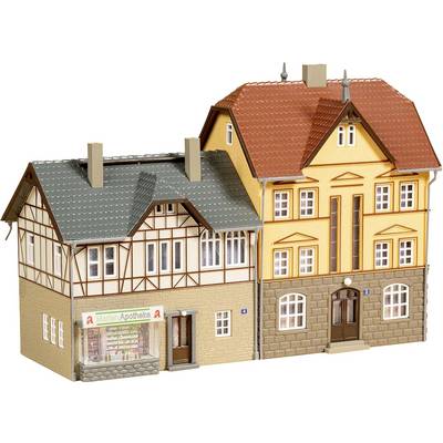 Deux bâtiments modèles adjacents ; à gauche, une maison à colombages avec 'Martin Apotheke', à droite, une maison jaune de trois étages avec un toit rouge.
