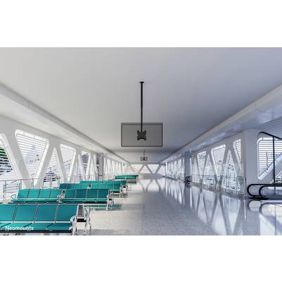 'Zone d'attente lumineuse dans un aéroport moderne avec des bancs verts et de grandes fenêtres. Escaliers roulants vides en arrière-plan.'