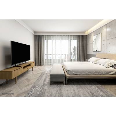 Une chambre moderne avec un grand lit, un miroir mural, une télévision sur une commode en bois et une fenêtre avec des rideaux occultants.