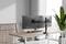 Deux écrans sont installés sur un support de moniteur ajustable sur un bureau près d'une fenêtre, avec une plante à côté, dans un environnement de bureau moderne.