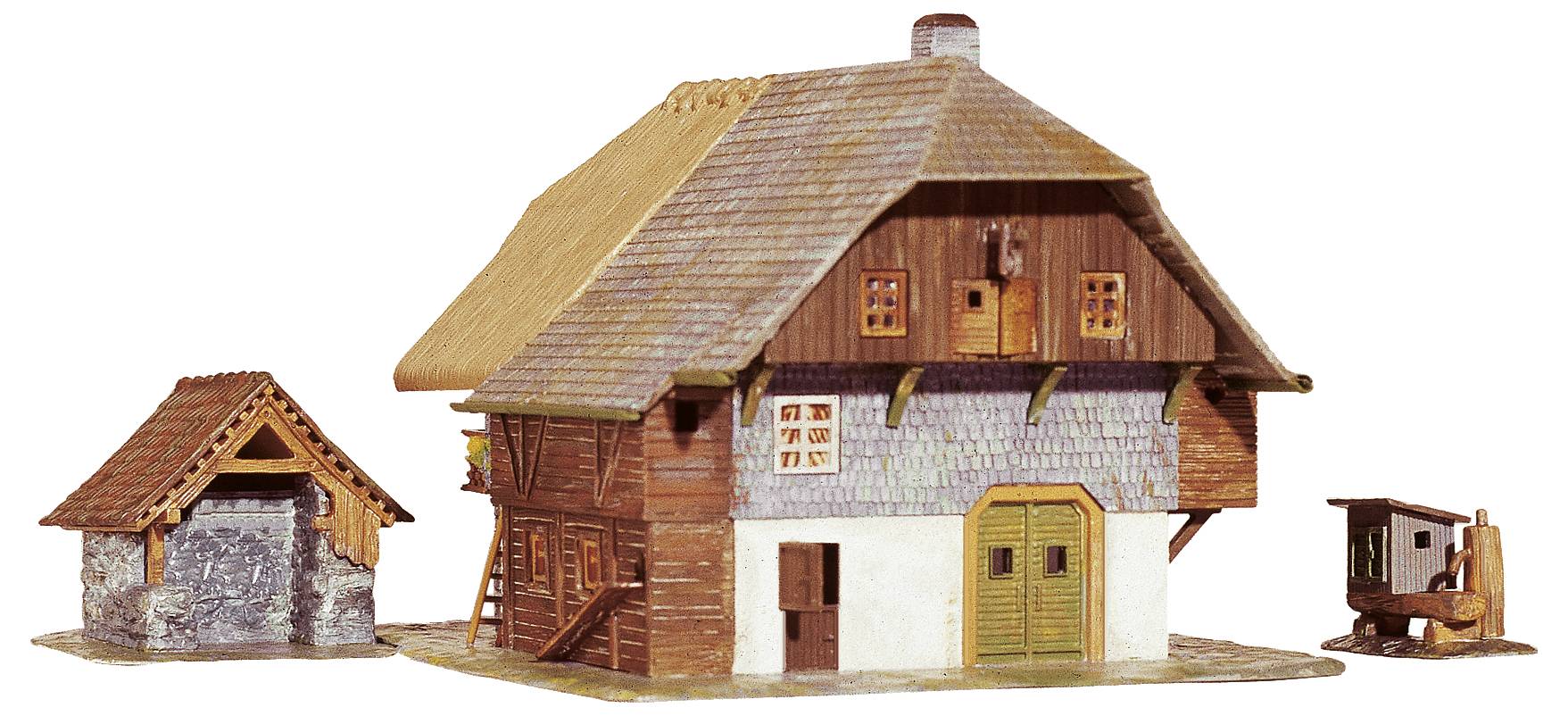 Une maison modèle de style traditionnel avec un toit de chaume, des murs en bois et des fenêtres. À côté se trouvent un petit hangar et une pompe à eau en bois.