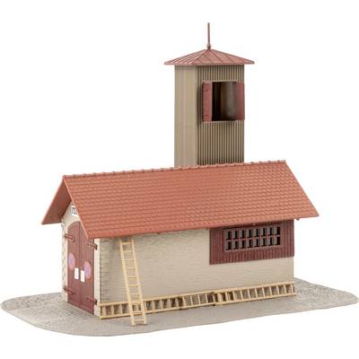 Petit bâtiment modèle avec un toit rouge, un revêtement en bois et une porte. Une échelle est posée sur le côté.