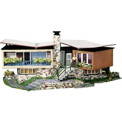 Une maison modèle de style classique avec une entrée et des escaliers en pierre. Deux personnages se tiennent sur la terrasse et à l'entrée.