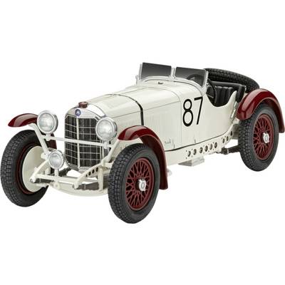 Une voiture de course ancienne blanche avec le numéro 87 sur le côté, une calandre rouge et des roues à rayons rouges, sur un fond blanc.