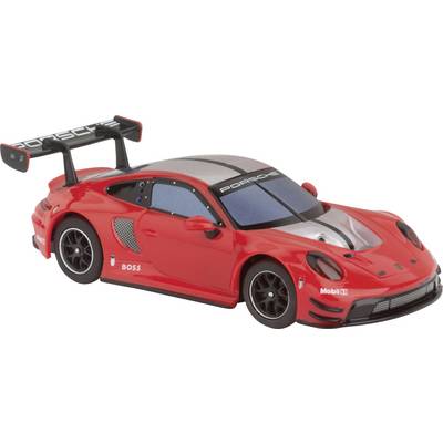 Une voiture de course miniature rouge avec le logo Porsche, un design aérodynamique et un aileron arrière.