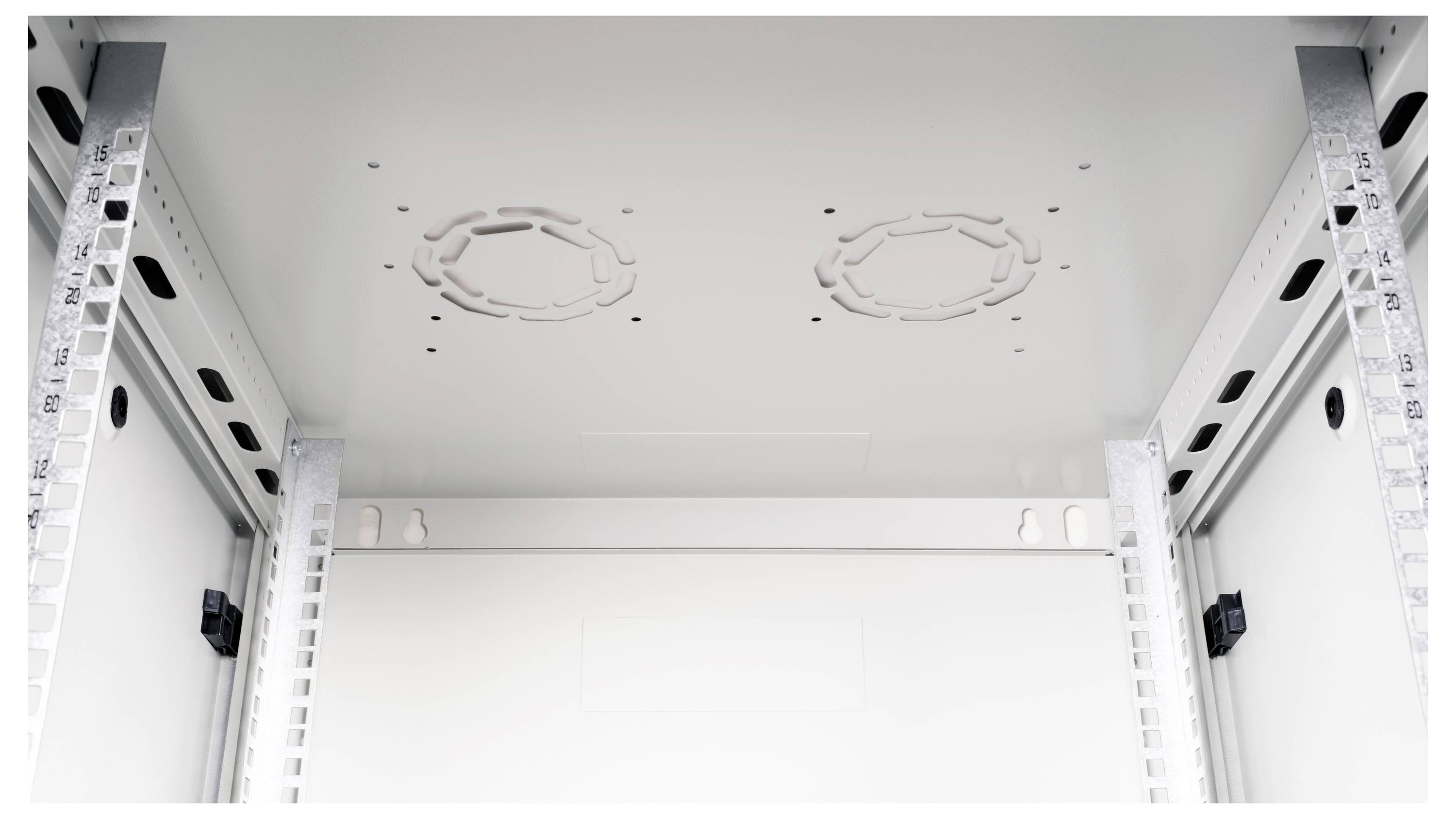 Vue intérieure d'un boîtier électrique métallique avec des supports de montage, des ouvertures de ventilation et un design ouvert et spacieux.