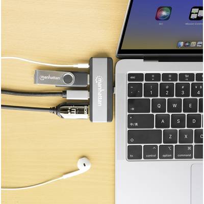 Ordinateur avec un hub USB connecté, relié par des câbles et une clé USB, avec un écouteur à côté. Poste de travail équipé de technologie.