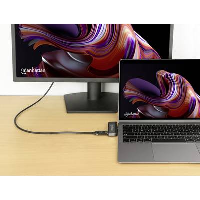Un ordinateur portable et un écran externe avec des graphiques abstraits identiques, reliés par un câble noir sur une table en bois.