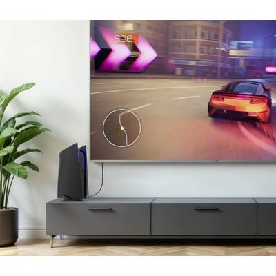 Un setup de jeu vidéo avec un grand téléviseur à écran plat affichant un jeu de course. Une console de jeu est posée à côté de l'écran sur un meuble.