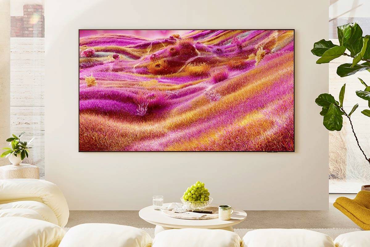 Une grande photographie représentant un paysage ondulant aux tons de rose et d'orange est accrochée sur un mur blanc dans un salon au design contemporain.