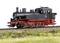 La locomotive à vapeur BR 78 roule sur une section de voie ferrée longeant une prairie. La locomotive a un châssis noir avec des détails rouges.