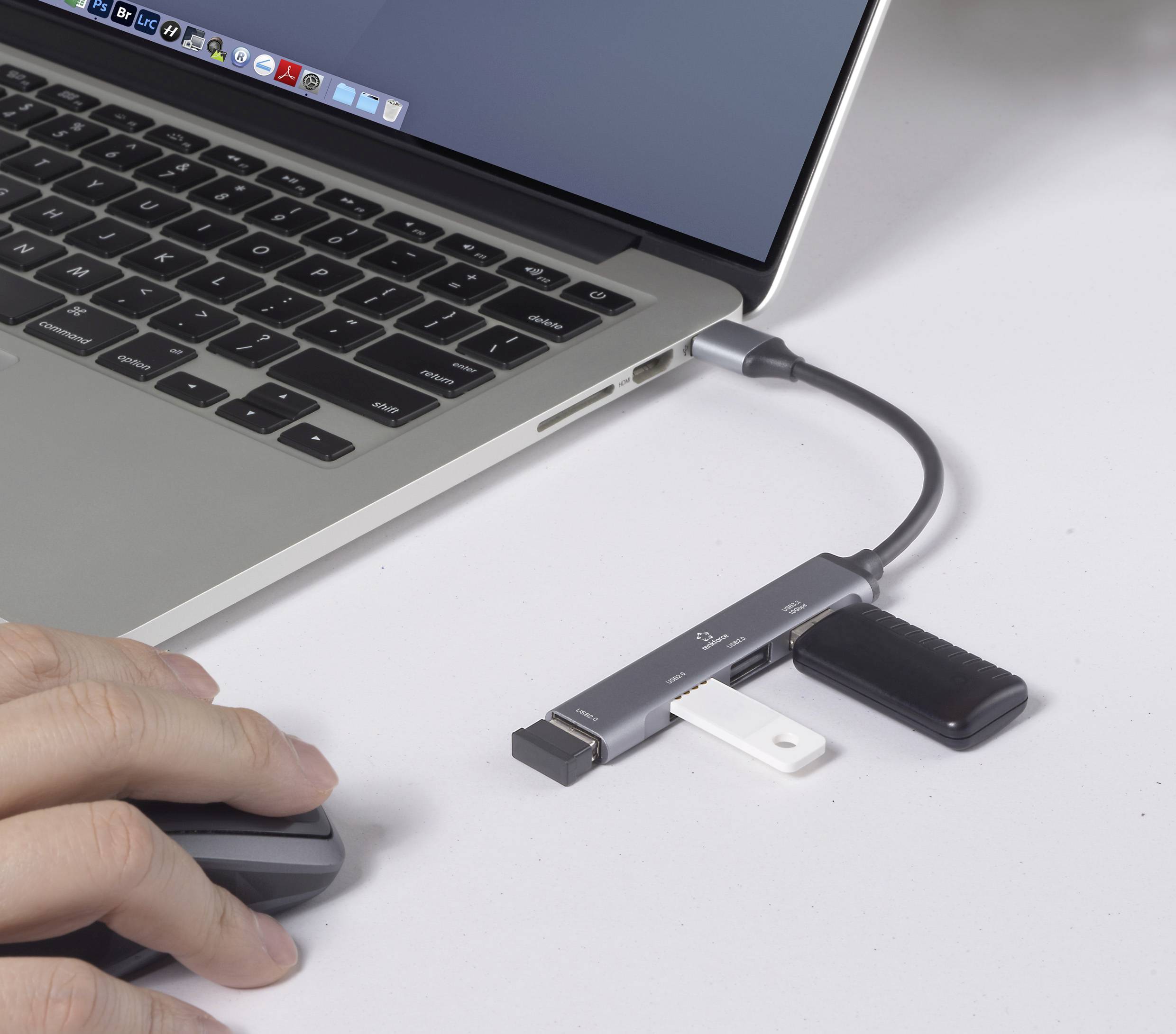 Un utilisateur utilise un ordinateur portable avec plusieurs périphériques USB connectés via un hub, illustrant une configuration de multitâche ou de transfert de données.