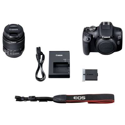 Appareil photo Canon avec objectif, câble de charge, chargeur, batterie et sangle de transport sur fond clair. Appareil photo et accessoires pour la photographie.