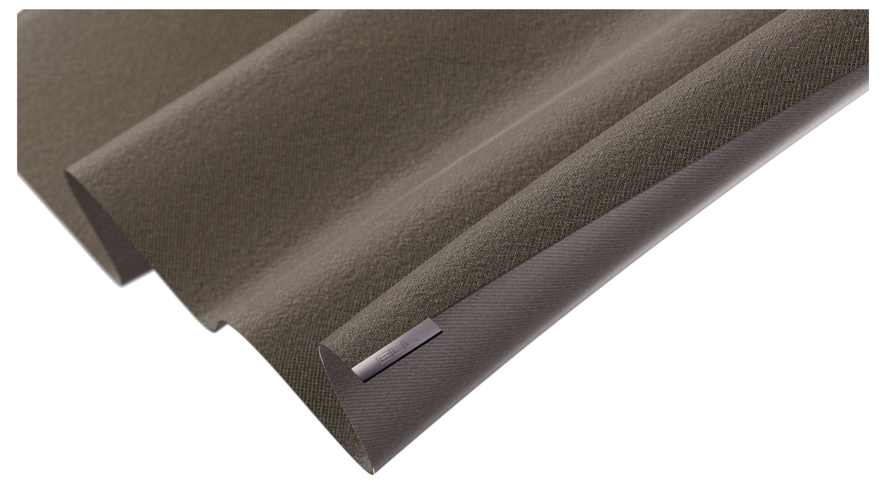 Gros plan d'un morceau de tissu ou de matériau brun plissé avec une petite plaque métallique sombre rectangulaire dans le coin.
