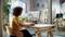 Une personne est assise dans un bureau lumineux, devant un bureau, regardant un écran d'ordinateur affichant un site web d'une agence de voyages avec diverses images de destinations.