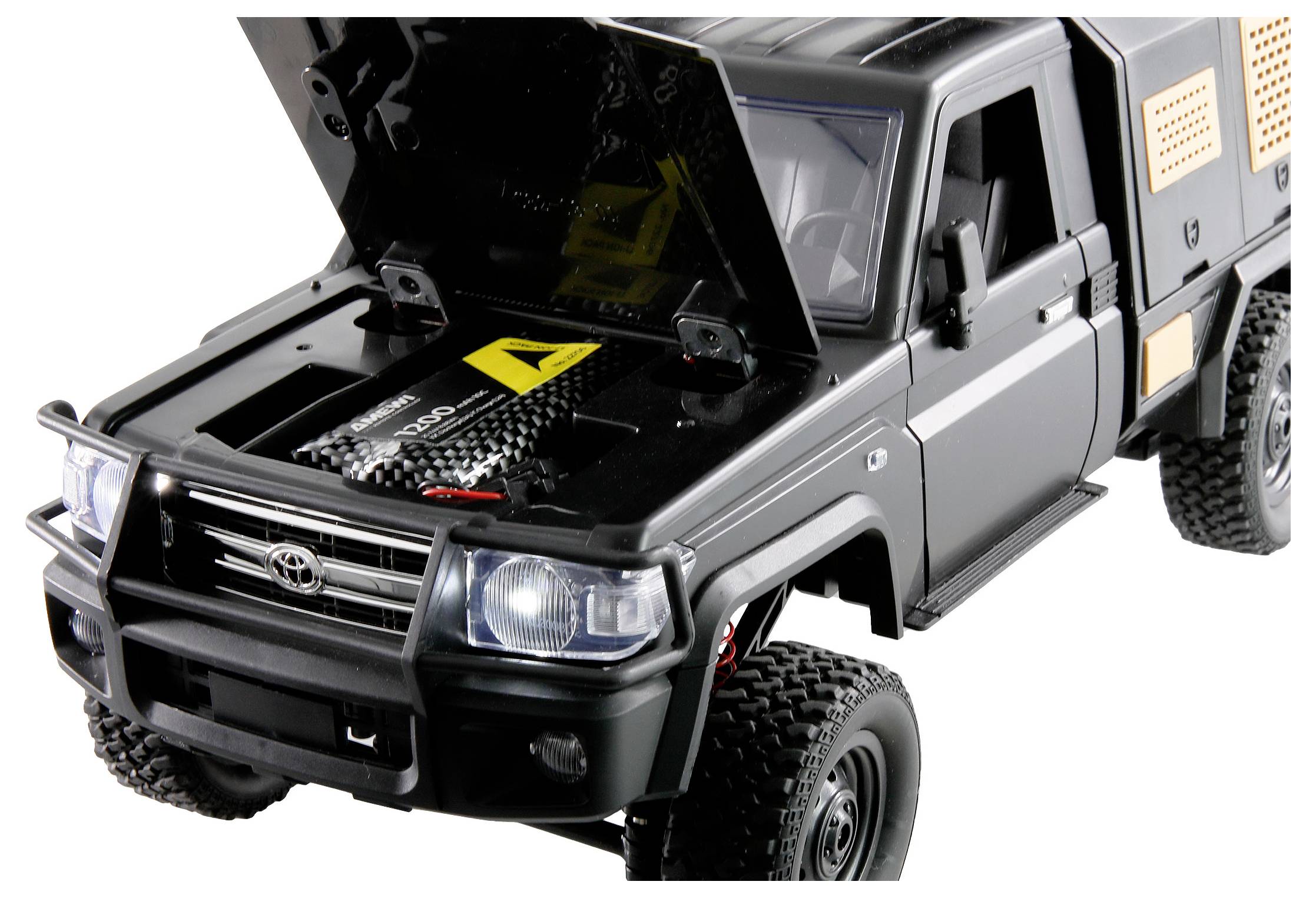 Une voiture miniature noire avec le compartiment moteur ouvert. Les portières et le capot sont ouverts, les détails de l'habitacle et du moteur sont visibles.