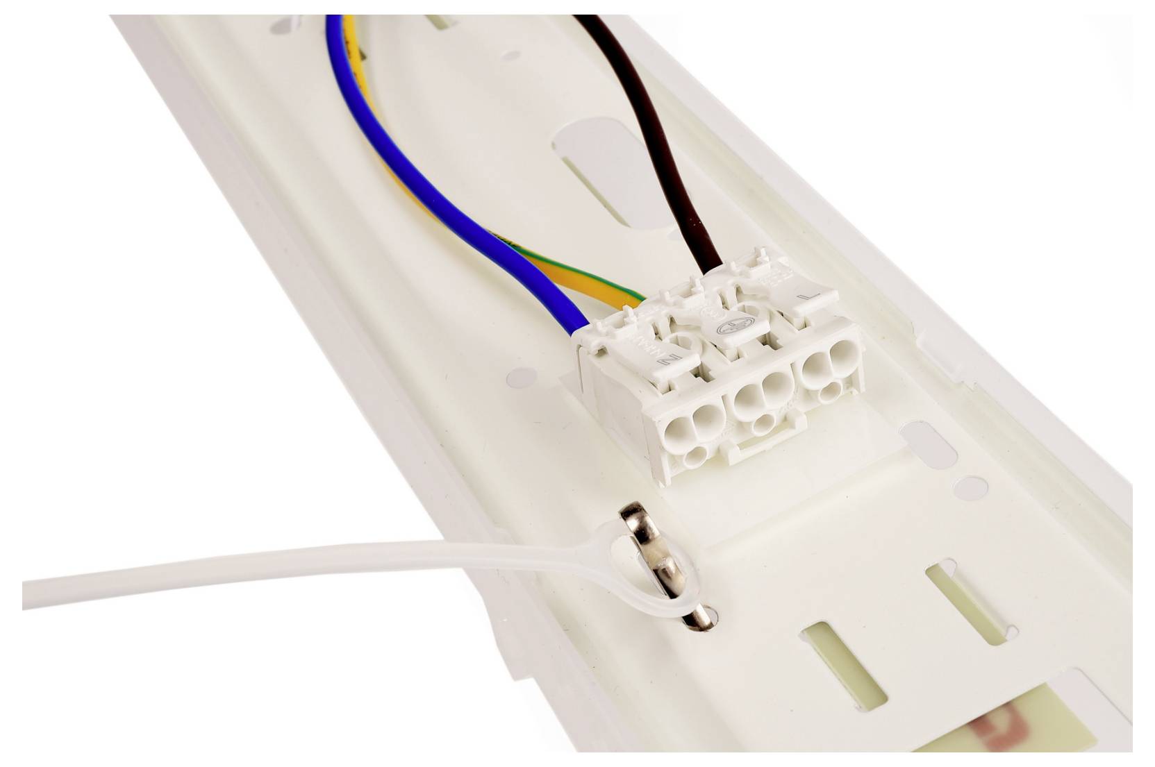 Gros plan d'un connecteur de câblage de luminaire avec des fils électriques bleu, marron et vert-jaune fixés à une plaque de montage blanche.