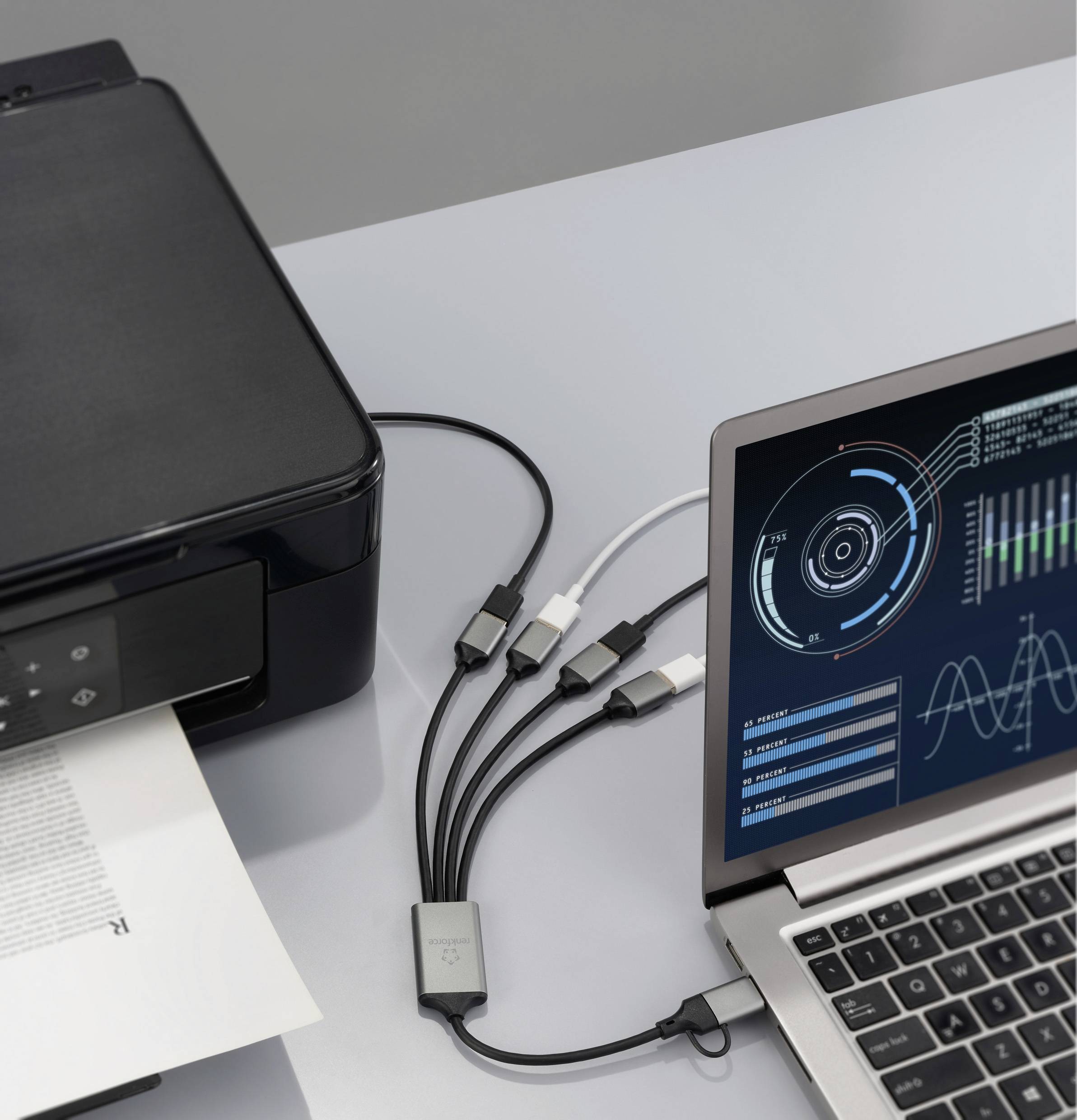 Un ordinateur portable avec un affichage de tableau de bord numérique est connecté à une imprimante via plusieurs câbles USB, indiquant un processus de transfert de données.