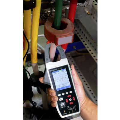 Un technicien mesure le courant électrique à l'aide d'un multimètre portable. L'écran affiche un motif en onde, et l'appareil est connecté à des fils.