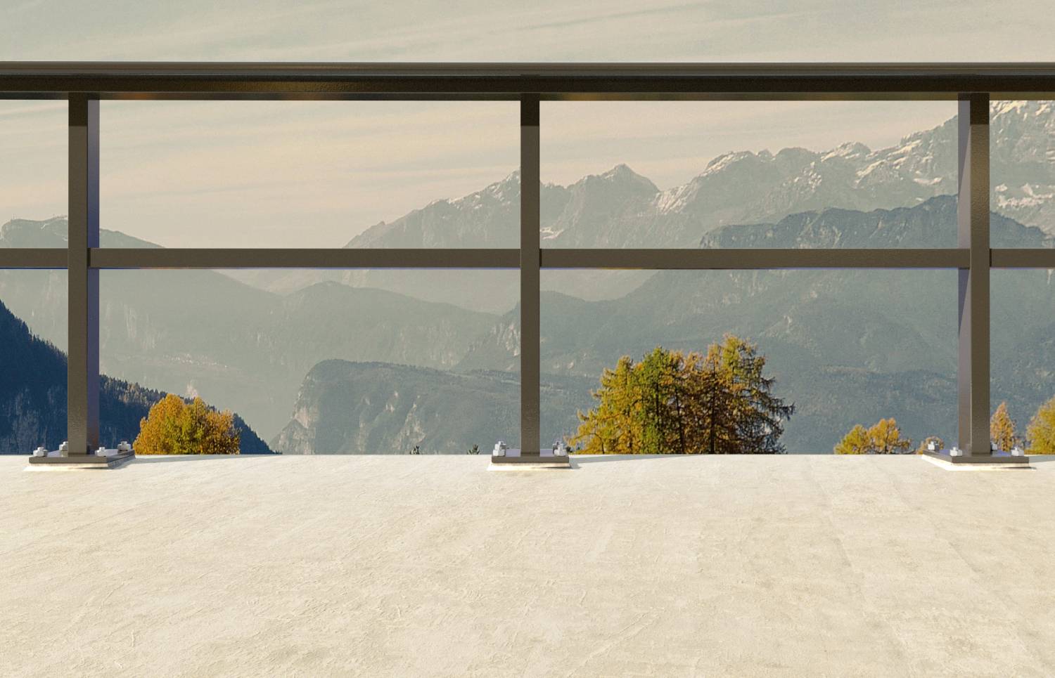 Vue sur la montagne à travers une rambarde vitrée d'une terrasse, avec des arbres automnaux et des sommets lointains sous un ciel dégagé.