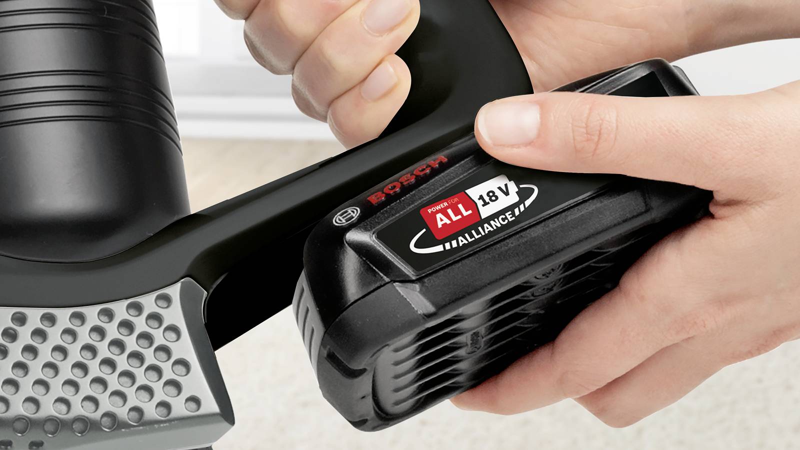 Une main insère un pack de batterie de 18V dans un outil Bosch, démontrant la compatibilité de la batterie avec le système 'POWER FOR ALL ALLIANCE' de 18V.