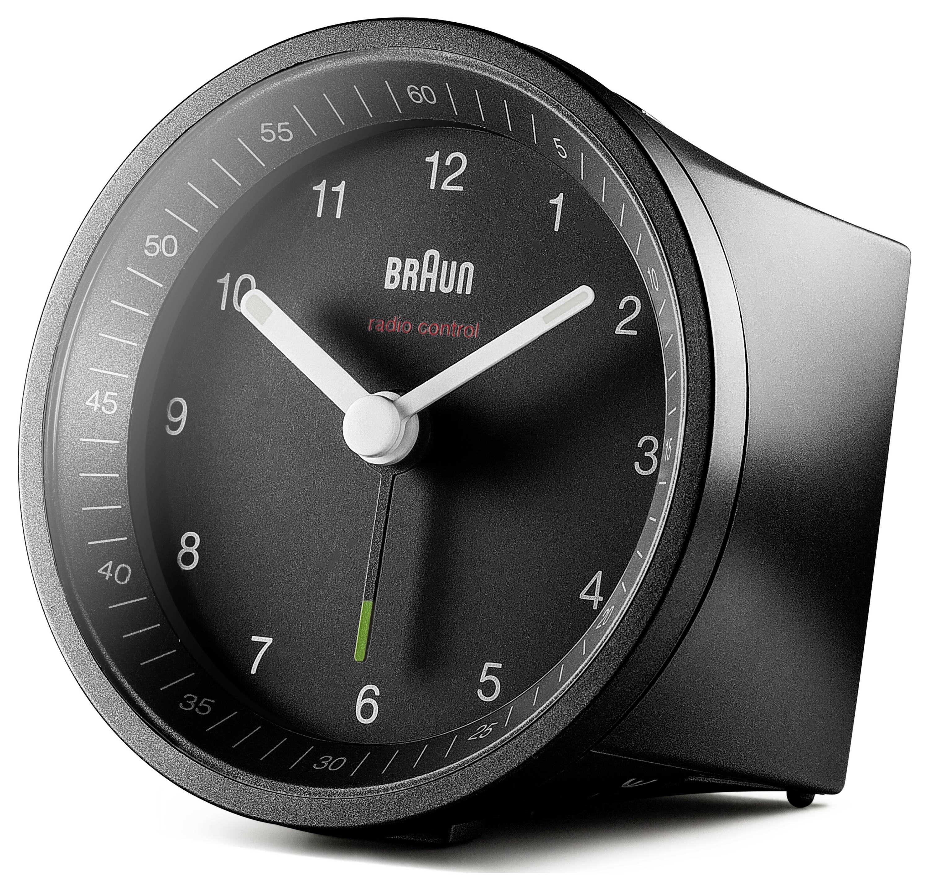 Une horloge réveille Braun noire avec des aiguilles et des chiffres blancs sur son cadran, indiquant 10h10. Une petite marque verte est visible près du bas.