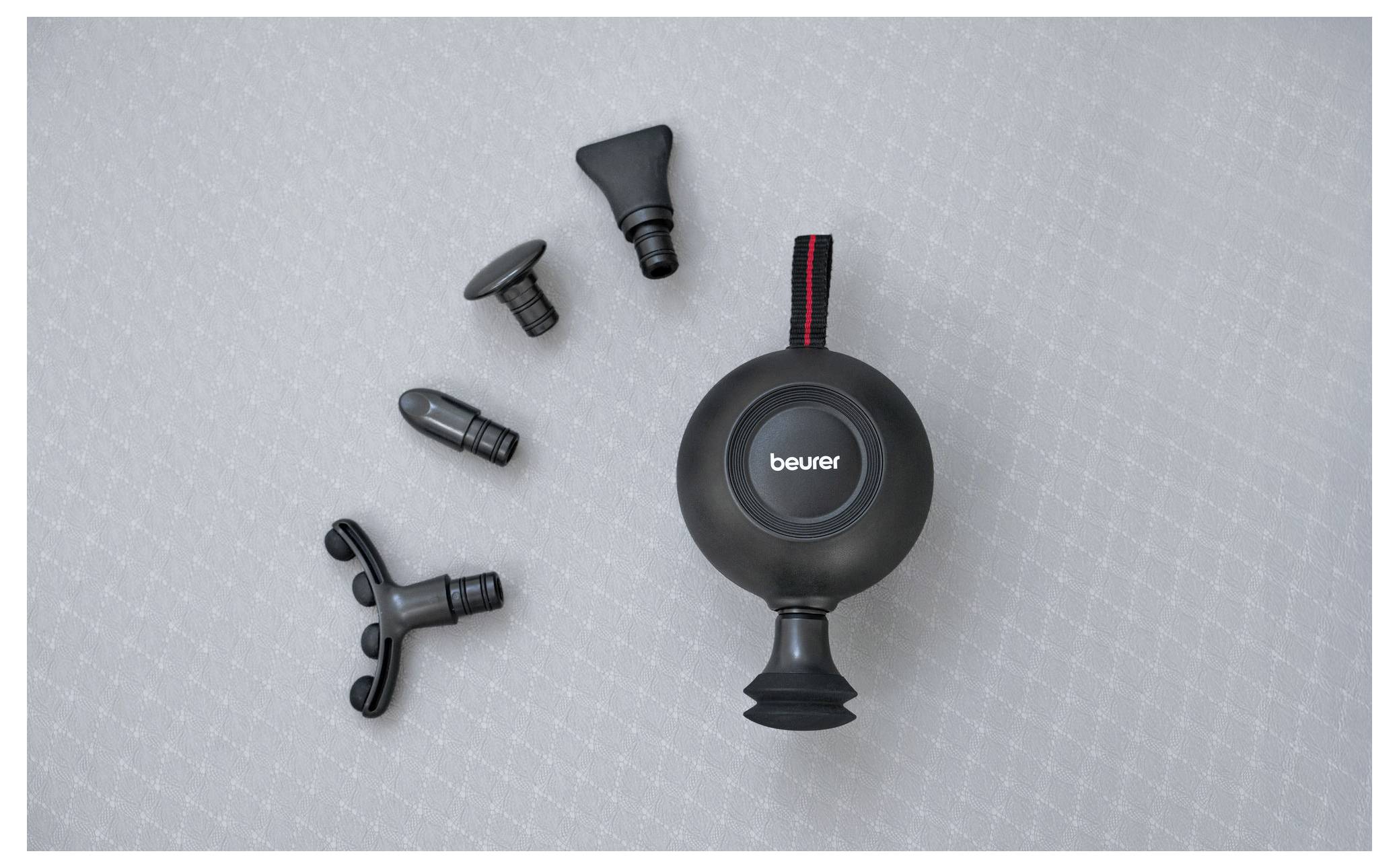 Un appareil de massage noir portable avec cinq embouts interchangeables pour différentes zones musculaires est présenté sur une surface texturée.