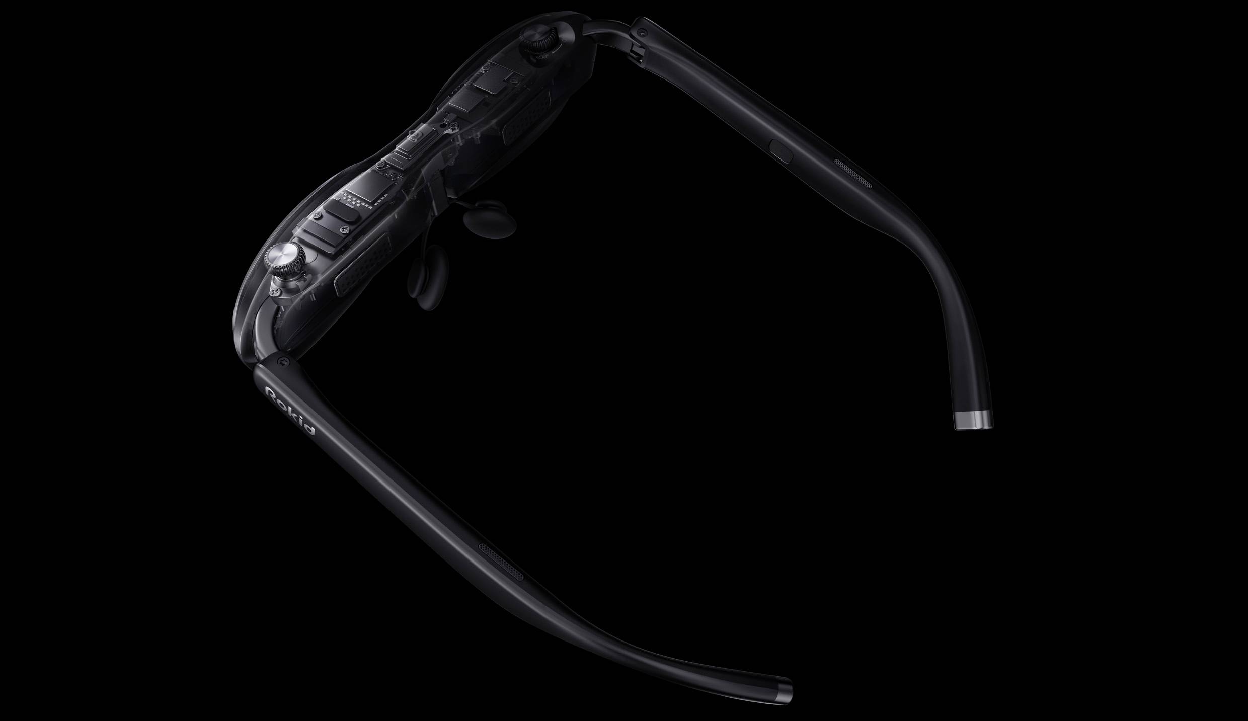 Des lunettes de réalité virtuelle noires élégantes, vues de dessus, montrant les détails de la branche et de la charnière sur un fond sombre.