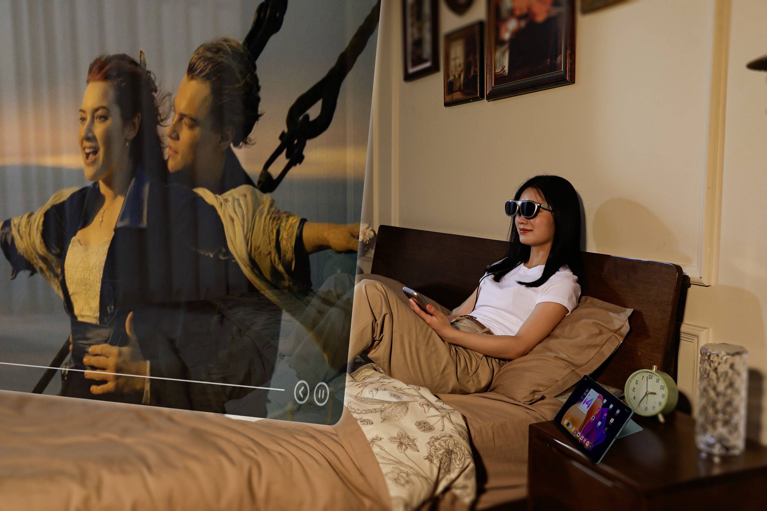 Une personne portant des lunettes de réalité virtuelle est allongée dans un lit, regardant une projection 3D d'une scène de film classique où un couple se tient sur le pont d'un navire.