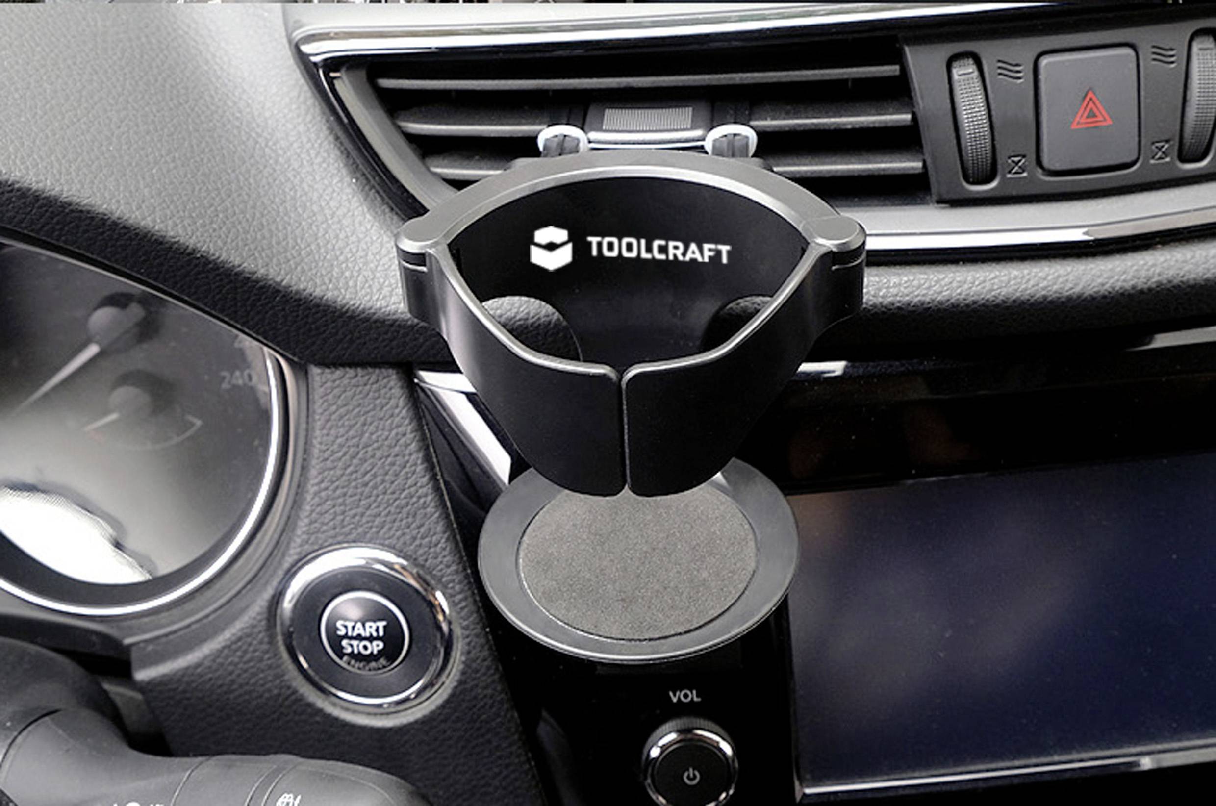 Tableau de bord de voiture avec un support de téléphone de marque 'Toolcraft' monté sur une grille d'aération, à côté d'un bouton de démarrage et des commandes du véhicule.