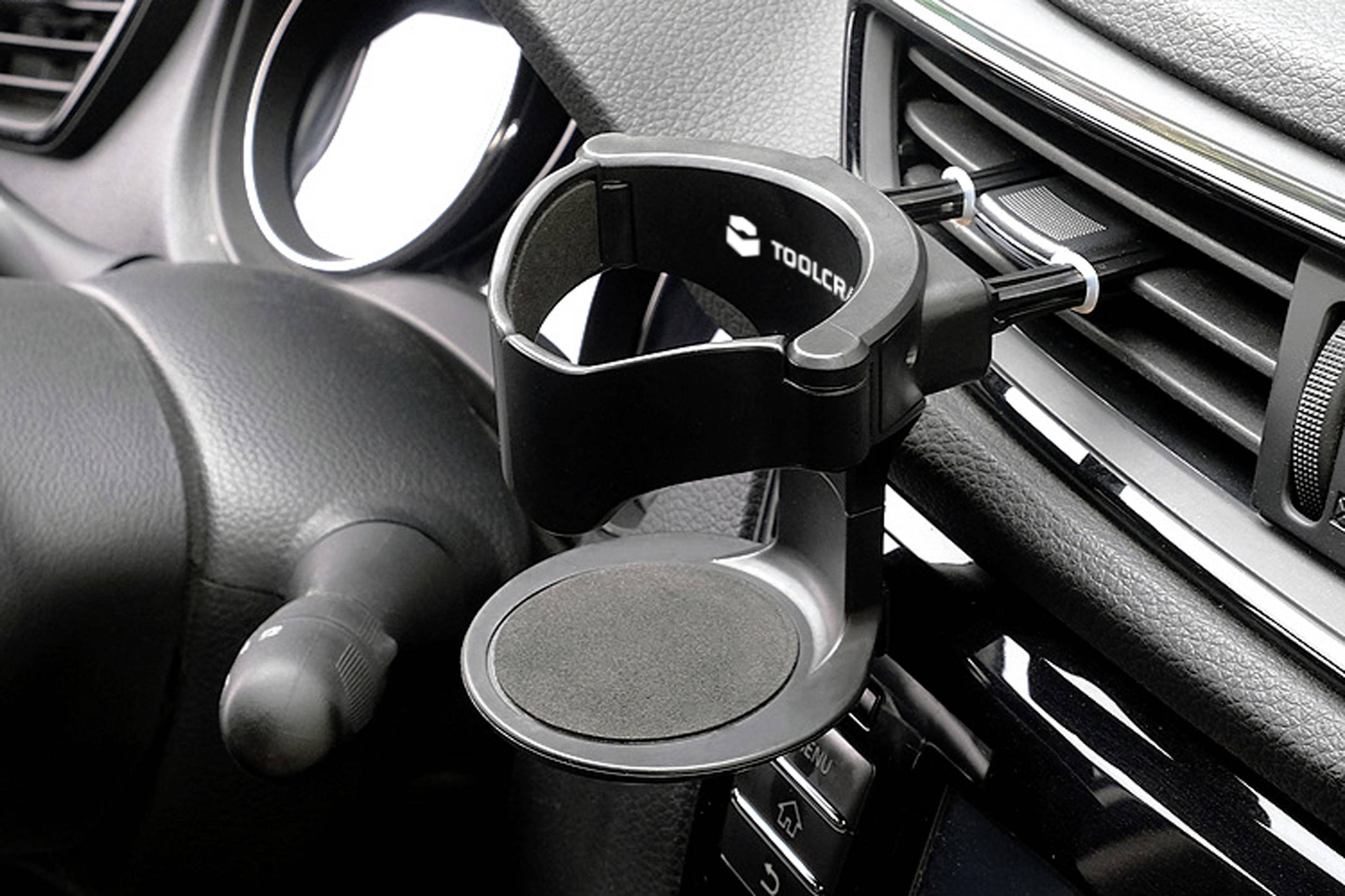 Support de téléphone pour voiture fixé sur la grille d'aération d'un véhicule, équipé d'un support réglable et d'une prise en main rembourrée pour un placement sécurisé du téléphone.