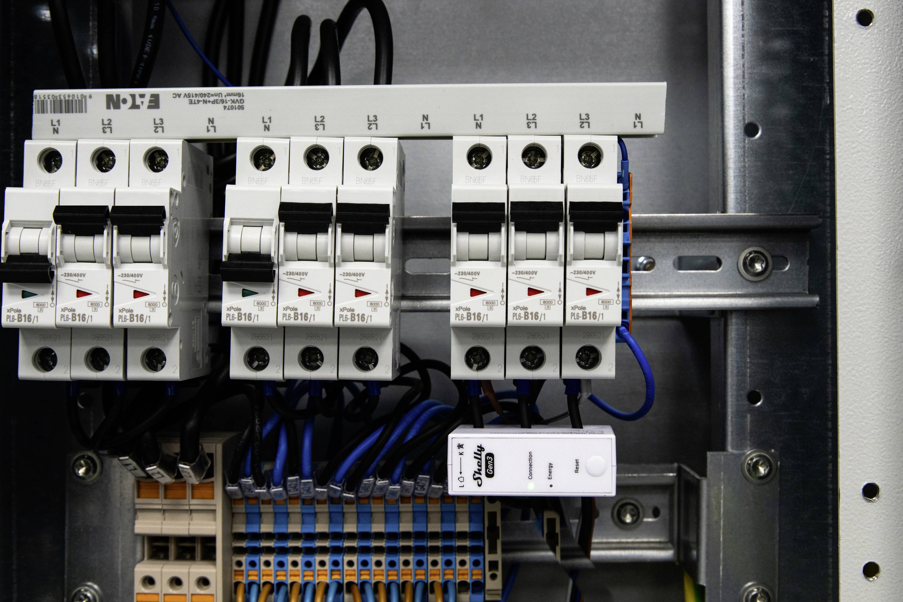 Disjoncteurs électriques et câblage à l'intérieur d'un tableau de commande.