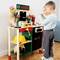 Des enfants jouent avec un établi de jouet, comprenant des outils et des accessoires de marque 'Bosch'.
