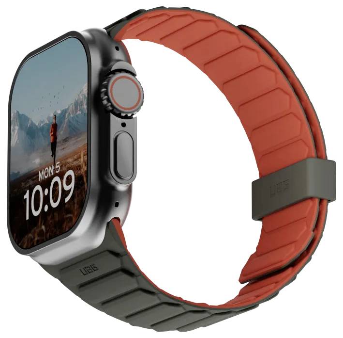 Montre connectée avec une sangle rouge et noire affichant un cadran numérique indiquant 'LUN 5' et '10:09'. Paysage de montagne en arrière-plan.