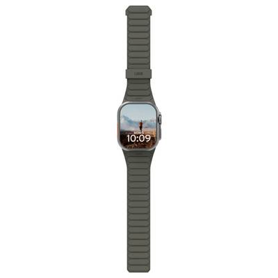 Une montre connectée affichant l'heure '10:09' sur son écran avec un randonneur et un paysage de montagne en arrière-plan. La montre a un bracelet foncé.
