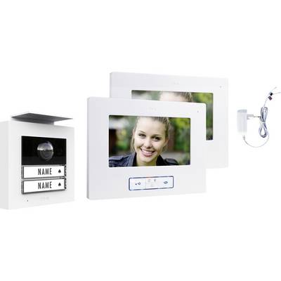 Un système d'interphone avec une caméra et deux écrans affichant une femme souriante. Comprend des plaques nominatives et un adaptateur secteur.