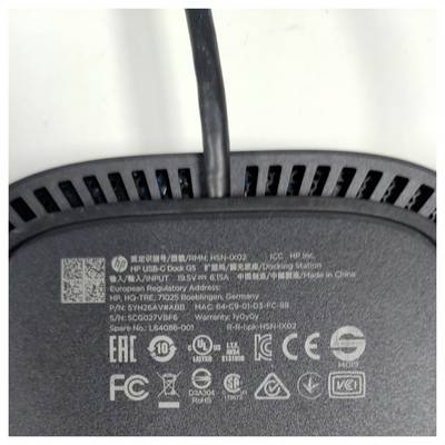 L'image montre le dessous d'un appareil HP sur lequel sont imprimés divers symboles réglementaires et certifications, ainsi qu'un câble d'alimentation.