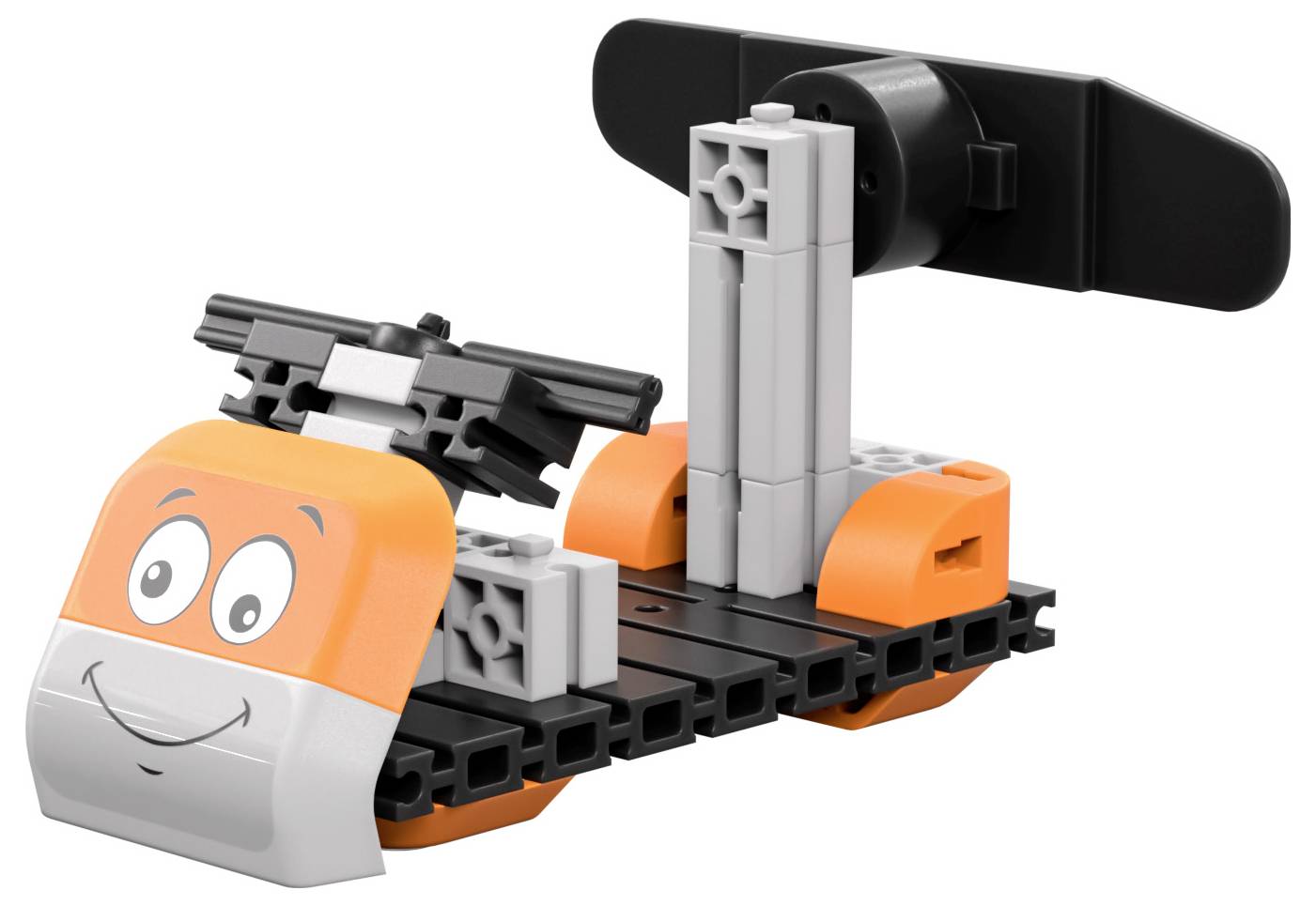 Un bateau jouet fait de briques en plastique emboîtables, avec un visage orange souriant à l'avant et une hélice noire à l'arrière.