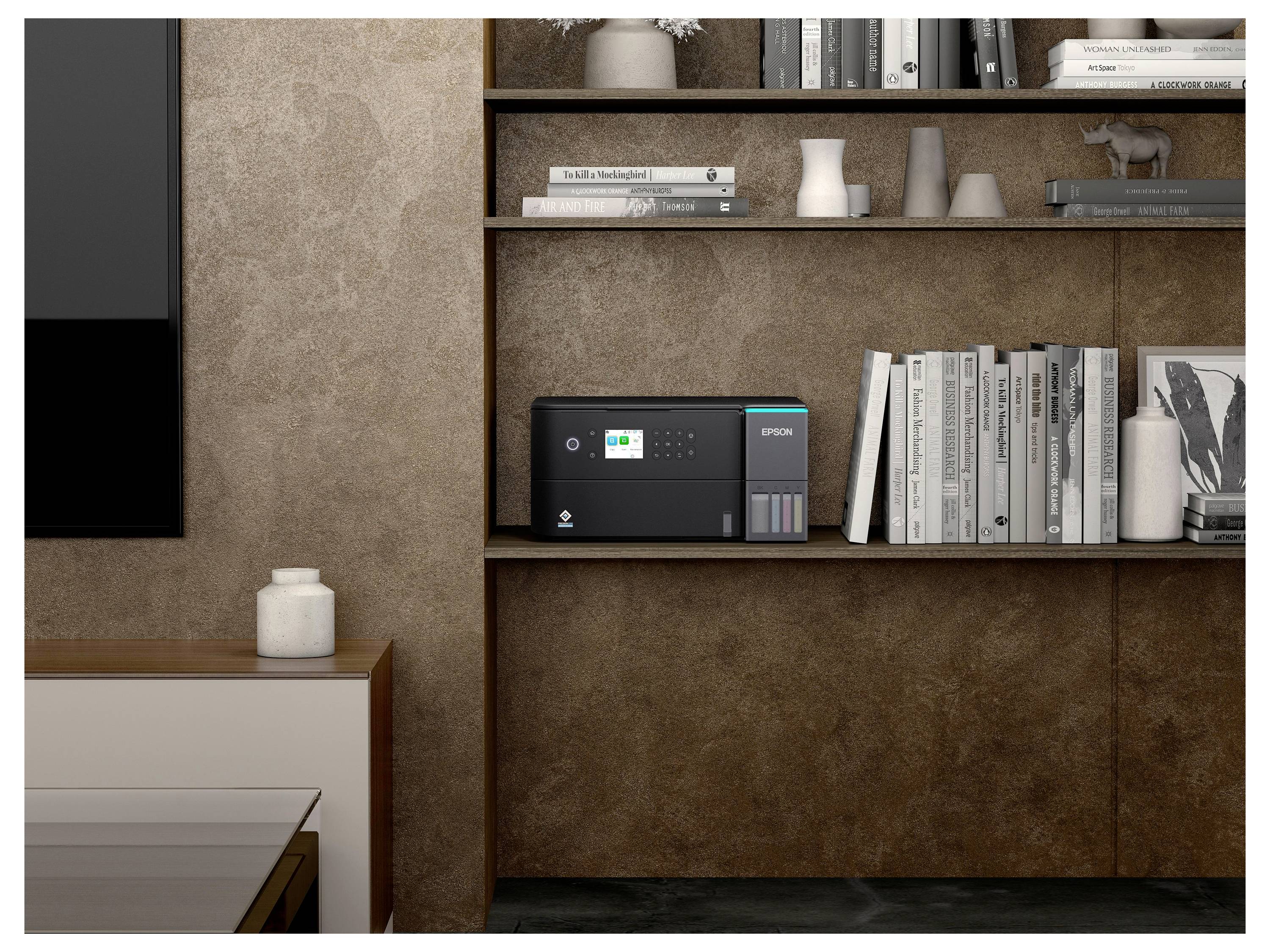 Un imprimante moderne est posée sur une étagère, entourée de livres et d'objets décoratifs, suggérant un espace de travail ou un bureau.