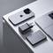 Un smartphone, un ordinateur portable, un chargeur portable et un adaptateur USB sont disposés avec soin sur une table, illustrant une configuration technologique minimaliste.