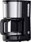 Un élégant cafetière en noir et acier inoxydable avec une carafe en verre, un indicateur de niveau d'eau et un bouton marche/arrêt à la base.