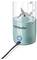 Un blender Nutribullet turquoise avec un gobelet doseur, un bouton marche visible et un cordon d'alimentation branché.