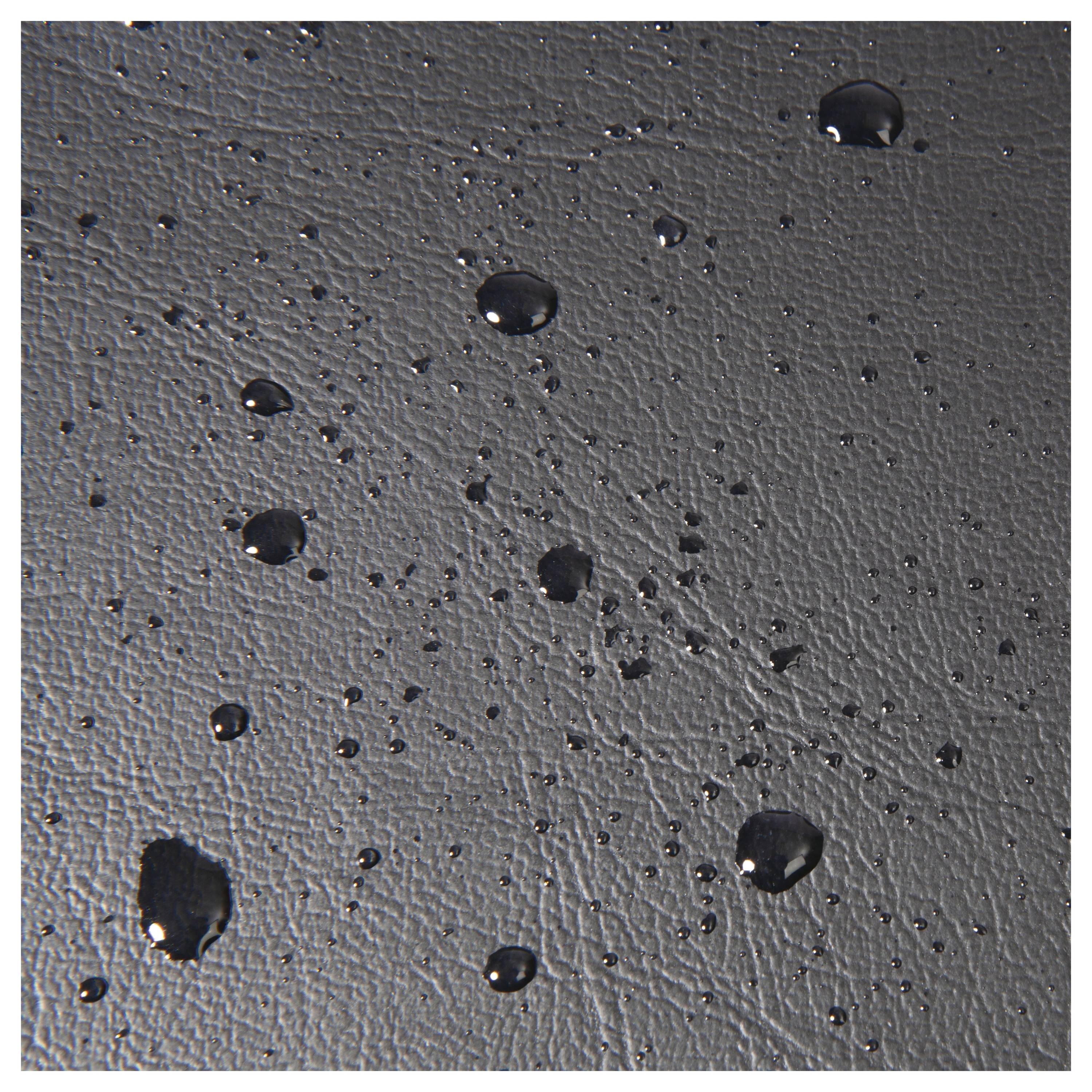 Gouttelettes d'eau sur une surface noire texturée, créant un motif et mettant en valeur la texture du matériau.