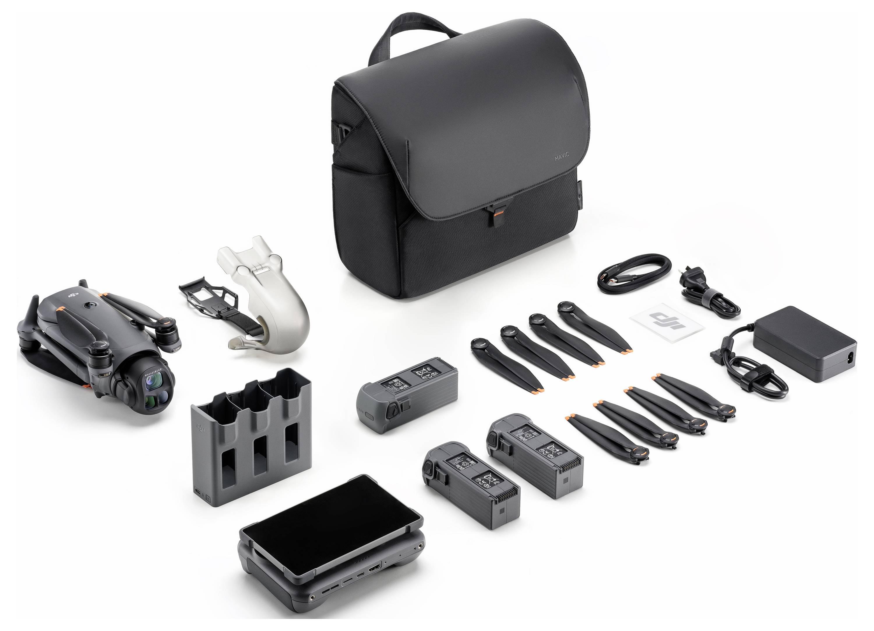 Un kit de drone complet comprenant un sac noir, un drone, des hélices, un hub de charge, deux batteries, une télécommande, des câbles et des accessoires supplémentaires.