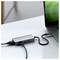 Un ordinateur portable connecté à un adaptateur multiport avec plusieurs câbles sur un bureau.