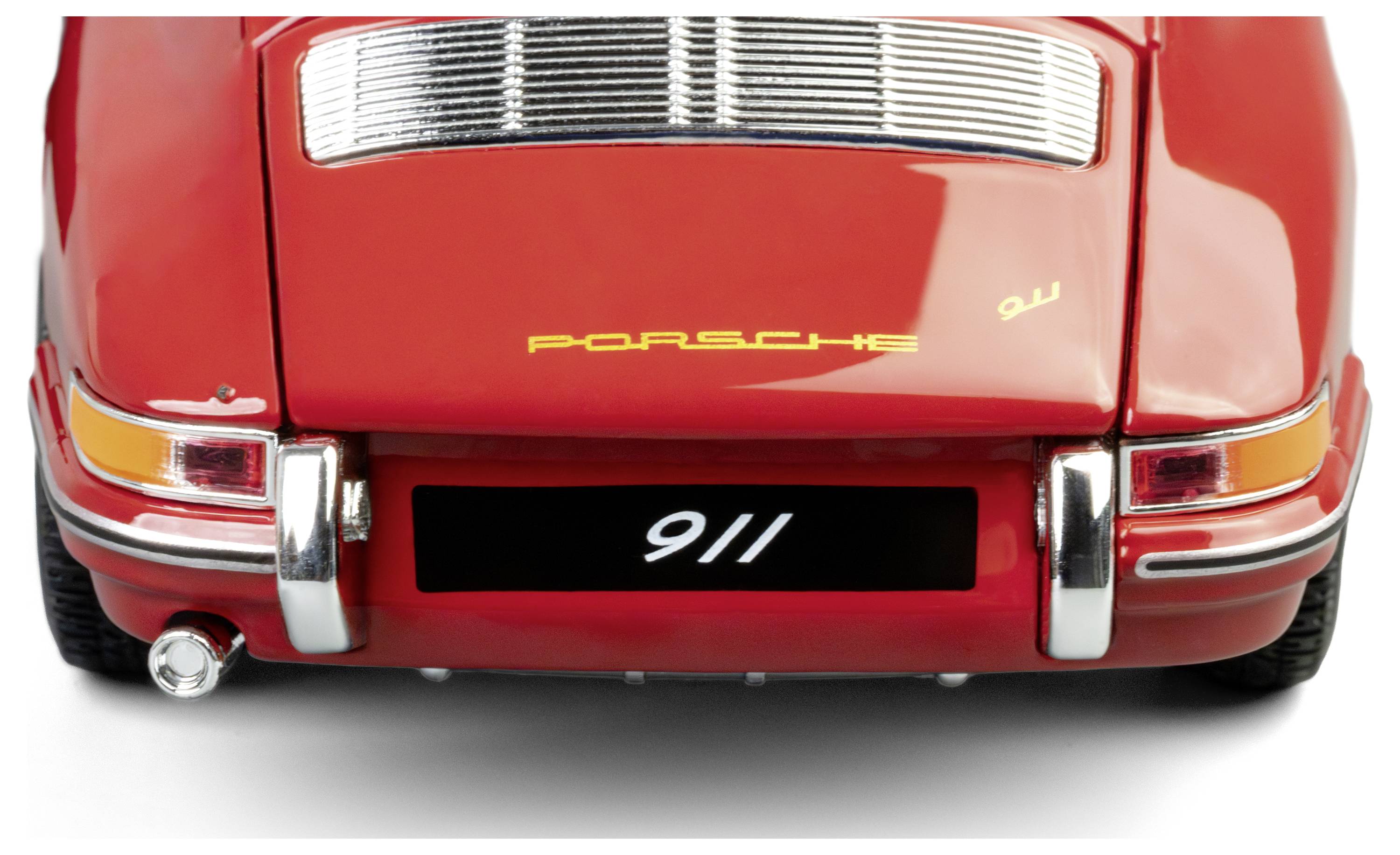 L'image montre la vue arrière d'une Porsche 911 classique rouge, mettant en valeur son logo et son design de queue distinctif.