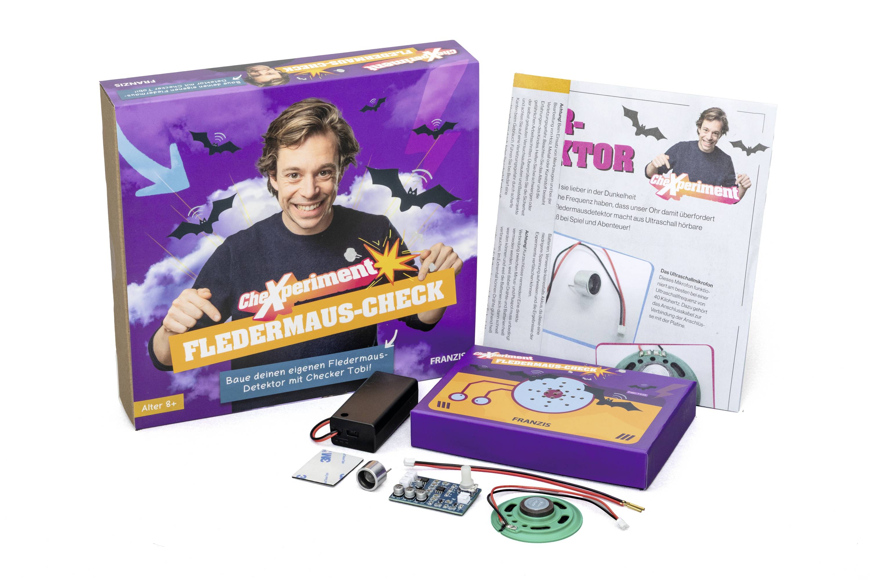 Un kit scientifique nommé 'Fledermaus-Check' présentant un homme souriant sur la boîte et divers composants électroniques pour l'expérimentation.