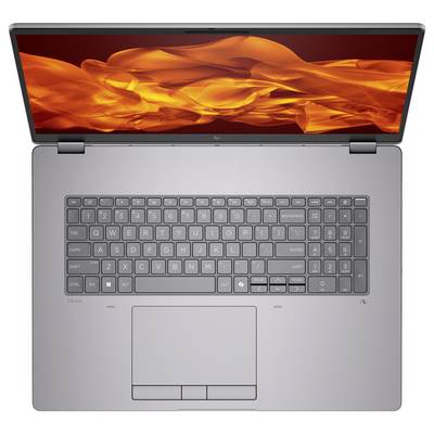 Un ordinateur portable argenté avec un clavier AZERTY, vu de dessus. L'écran affiche des flammes orangées abstraites, suggérant des performances élevées.