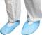 Personne portant un pantalon de protection blanc et des sur-chaussures bleues, indiquant un environnement propre ou stérile.