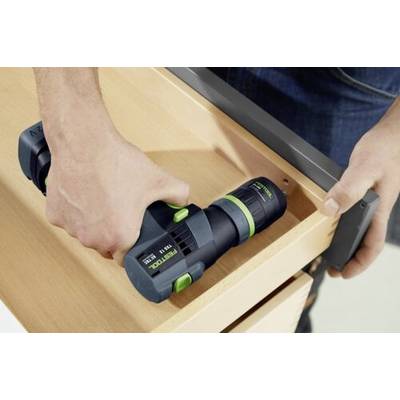 Une personne utilise une perceuse électrique pour fixer une poignée à un tiroir en bois, démontrant l'assemblage de meuble.
